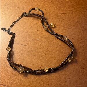 This is a multi-strand beaded necklace with brown and amber-tone glass beads.